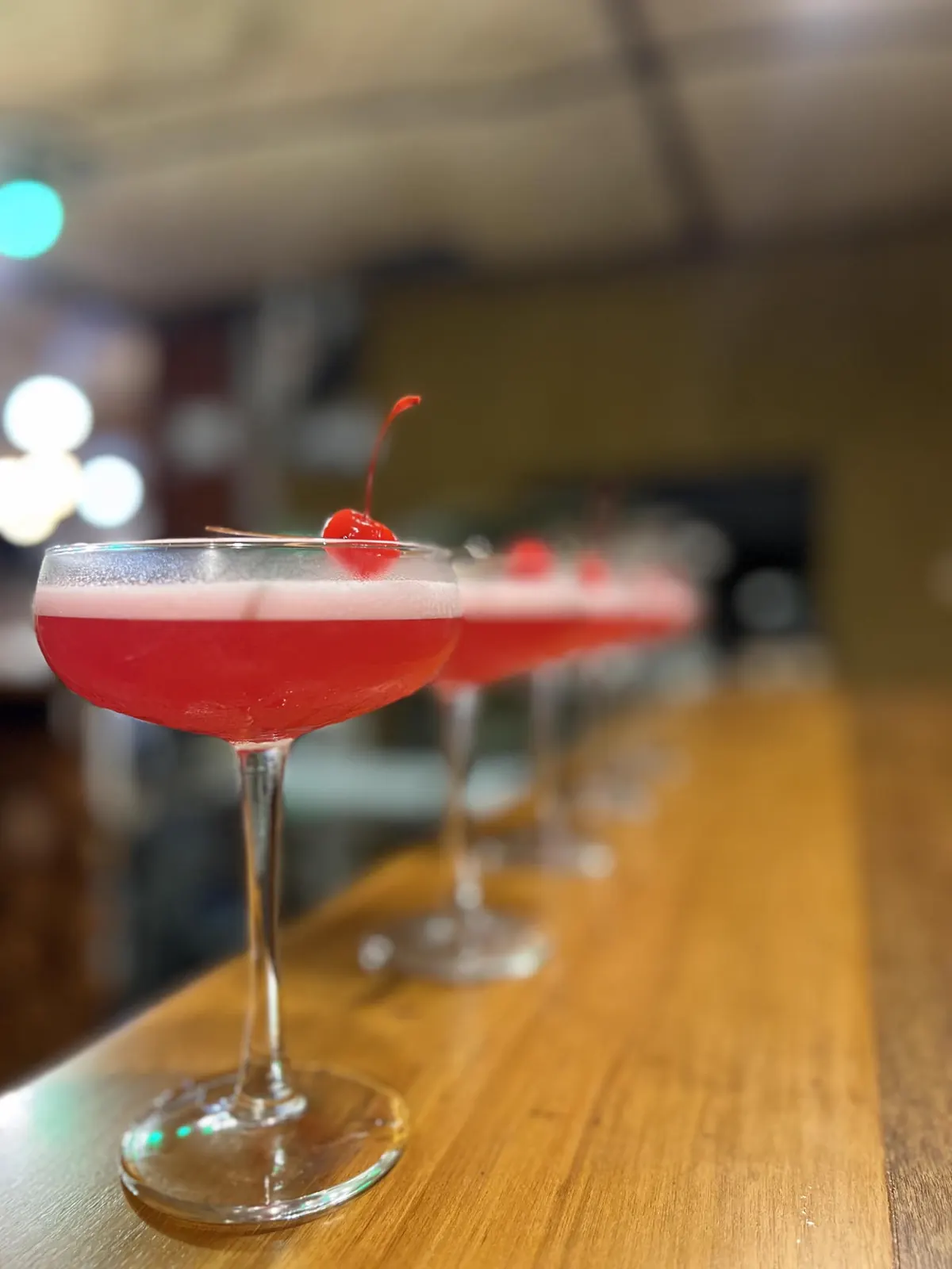 Pink coupes lined up on the wooden bar