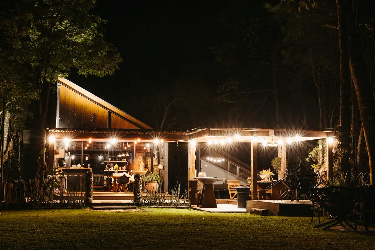 Garden dining lit by warm lights at night